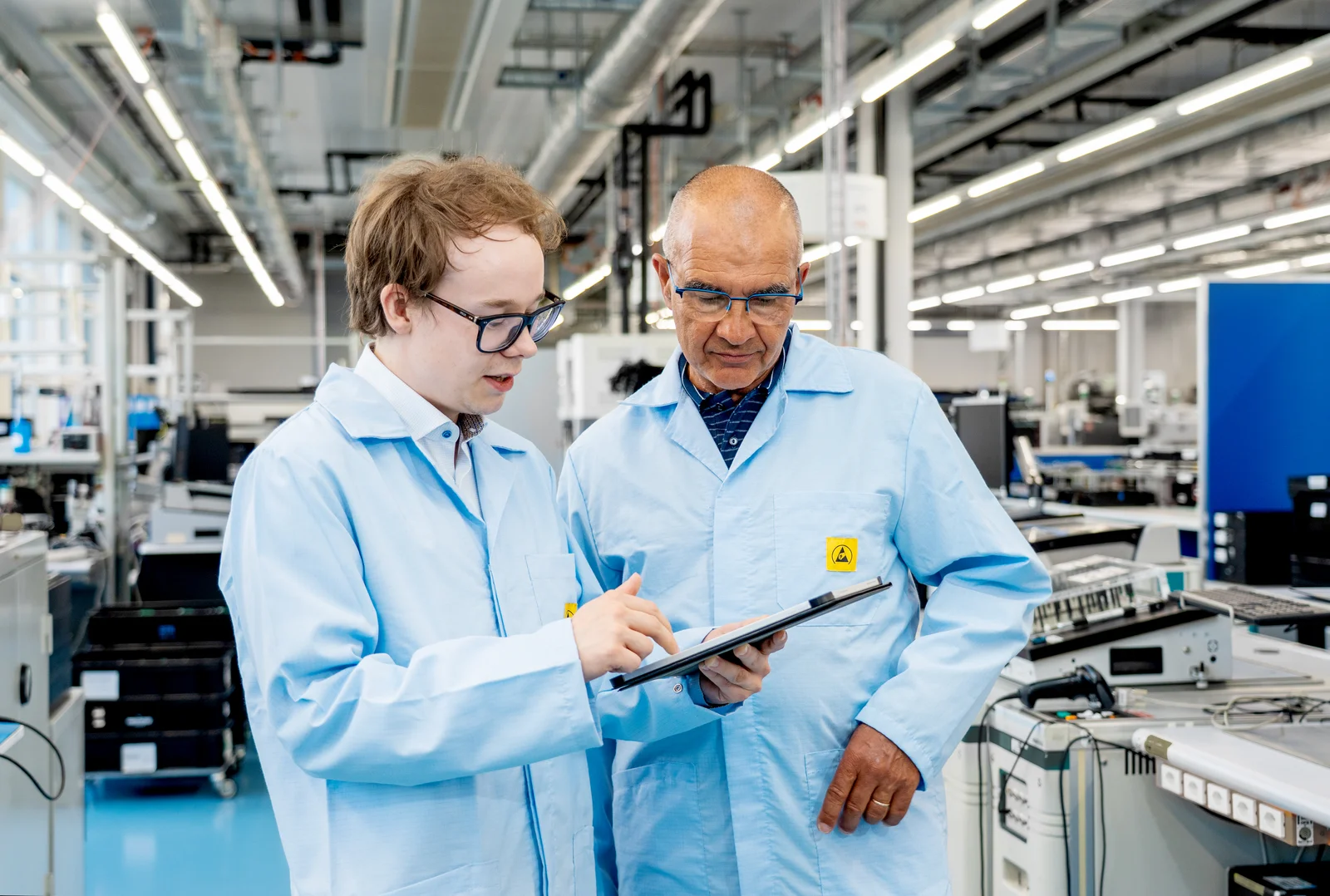 Elias Kettunen and Olivier Roy from Cicor discussing technical details on a tablet in a production environment.