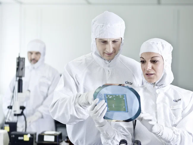 Cicor employees inspecting a thin-film substrate at the Cicor production site in Wangs, Switzerland
