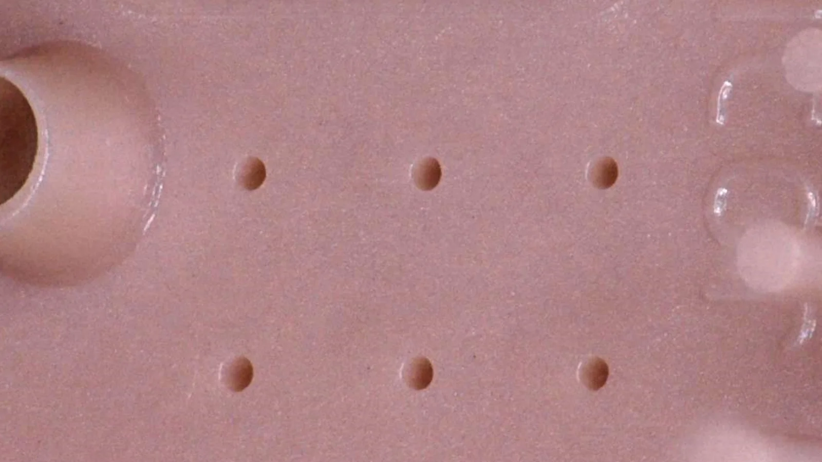 Close-up of a micro-molded plastic part demonstrating Cicor's precision plastics capabilities.