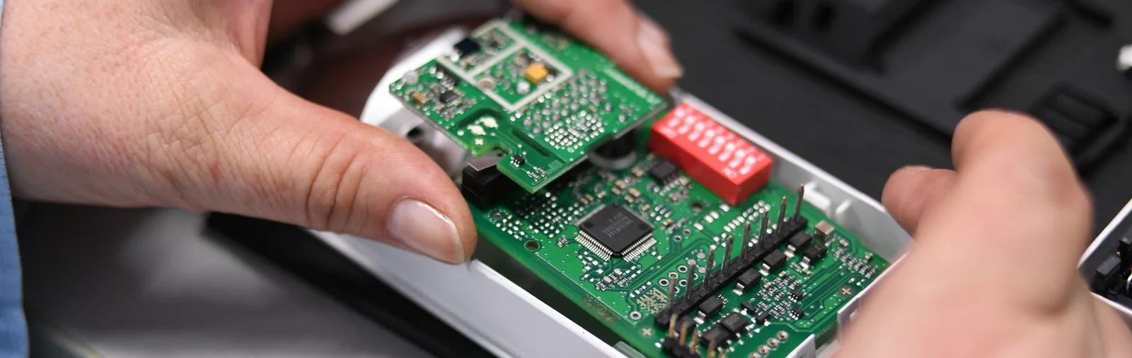 Close-up of a Cicor employee integrating a PCB into a housing (box building)