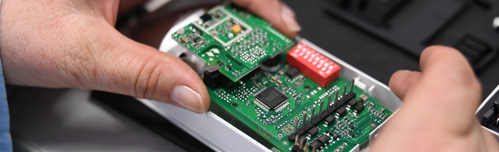 Close-up of a Cicor employee integrating a PCB into a housing (box building)