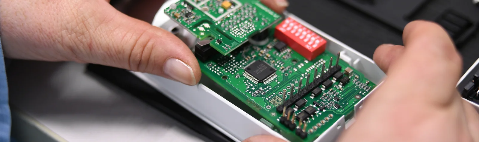 Close-up of a Cicor employee integrating a PCB into a housing (box building)