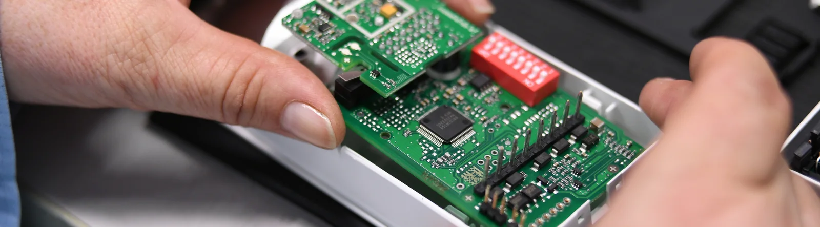 Close-up of a Cicor employee integrating a PCB into a housing (box building)