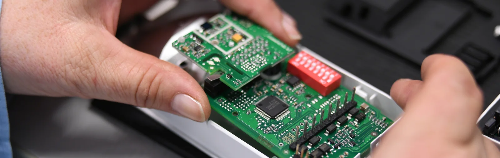 Close-up of a Cicor employee integrating a PCB into a housing (box building)