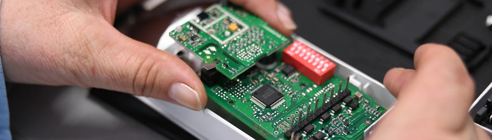 Close-up of a Cicor employee integrating a PCB into a housing (box building)