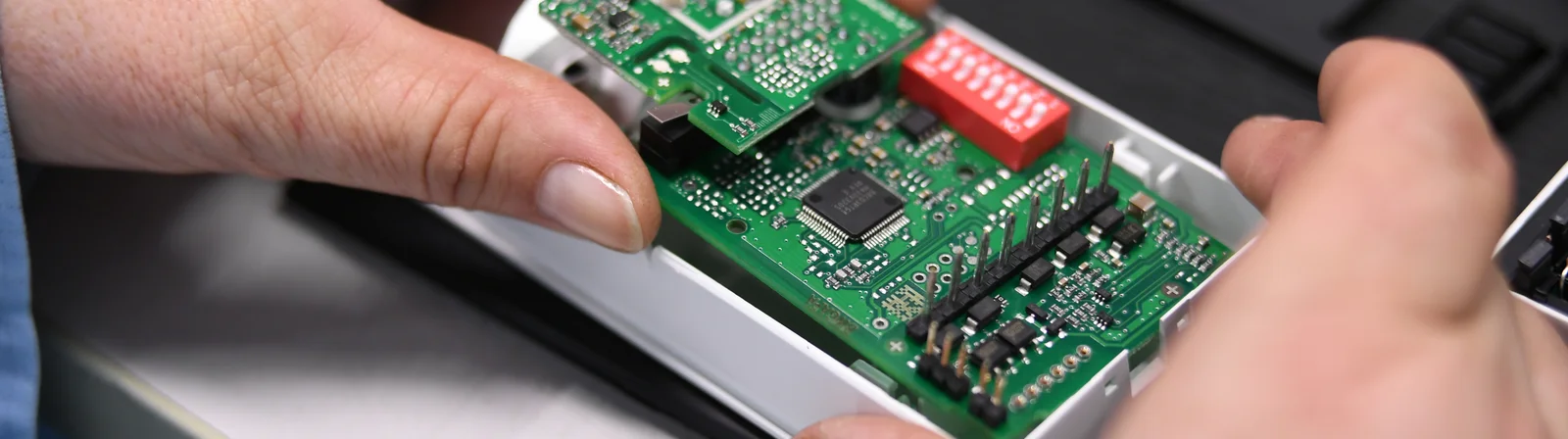 Close-up of a Cicor employee integrating a PCB into a housing (box building)