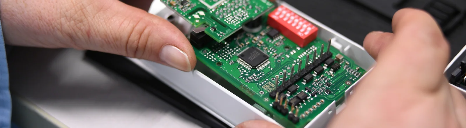 Close-up of a Cicor employee integrating a PCB into a housing (box building)