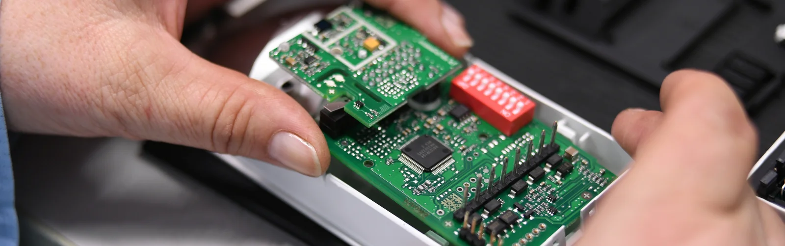 Close-up of a Cicor employee integrating a PCB into a housing (box building)