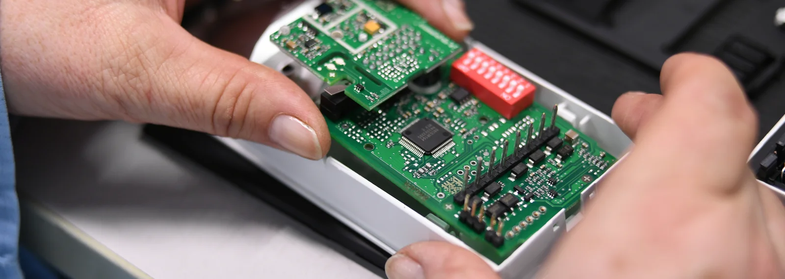 Close-up of a Cicor employee integrating a PCB into a housing (box building)