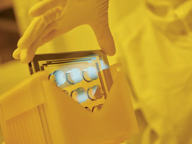 Cicor employee holding a thin-film substate at the production site in Wangs, Switzerland