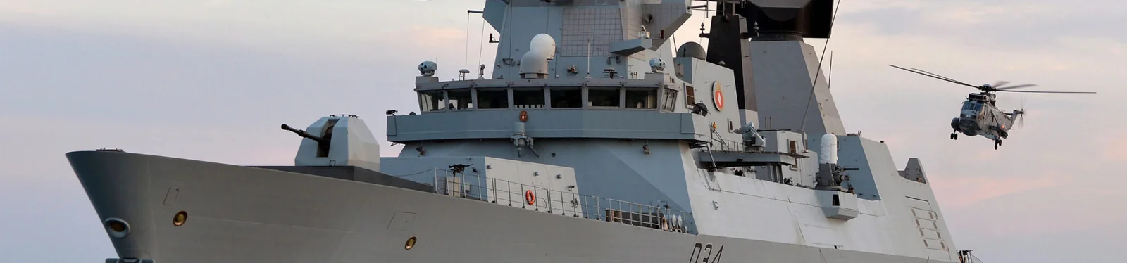 Modern naval frigate (Type 45) at sea with helicopter, representing Cicor maritime electronics systems.